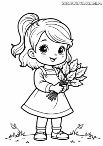 Dziewczynka z liśćmi w rękach na trawie